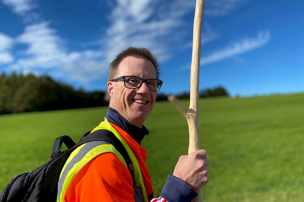 Bild zeigt eine Person mit Wanderstock.