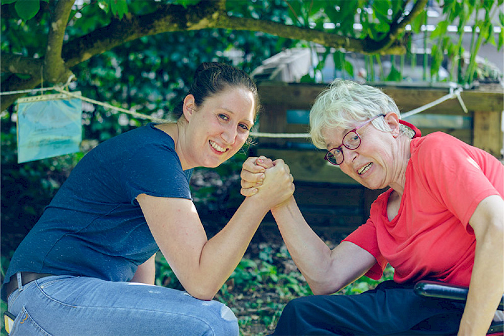 Bild zeigt zwei Personen mit einer Geste der Stärke.