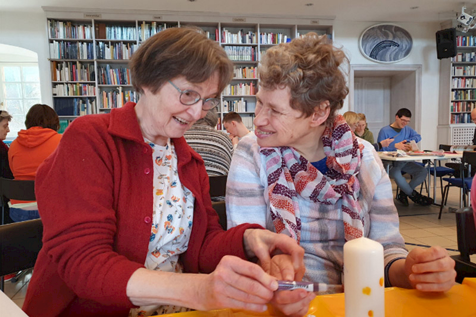 Bild zeigt zwei Personen an einem Tisch sitzend.